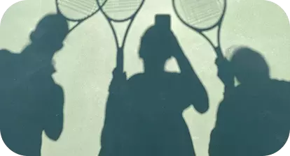 Tre persone in ombra sul campo da tennis, con racchette alzate
